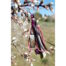 Porte-Clefs Ciewenn composé d’un pompon fait à la main avec des rubans, des suédines et des cordons. Il est décoré de perles violettes , d’une breloque argentée et multicolore.
