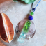 Collier hippie chic Ciewenn composé d'un cordon bleu, de perles bleues, vertes et argenté, d'une dentelle, de pampilles vertes, bleues et argentées.