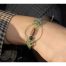 Ce Bracelet bohème Ciewenn est composé d'un cordon en micro-macramé vert et d'un cercle décoré de perles dorées, vertes, bois marron et noires.