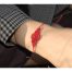 Ce Bracelet bohème Ciewenn, en micro-macramé fait main, est composé d’un fin cordon orné de fines boucles et d’arabesques rouges.