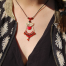 Collier bohème CieWenn composé d'un cordon, d'un micro macramé, d'une goutte bronze, de pampilles et de perles rouges, oranges noires et bronze