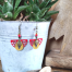 Boucles d'oreilles hippies chics Ciewenn composées de perles colorées et d'un jeu de pampilles rouges, grises, moutarde et bronze aux formes variées