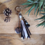 Porte-clefs Ciewenn composé de perles, d’une pampille, d’un pompon, fait main, avec rubans, suédines, de ton argenté et camaïeu de gris et noir,