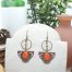 Boucles d'oreilles art déco CieWenn composées d'un cercle, de perles colorées, d'un éventail mauve, un disque bronze, d'une goutte oranges.